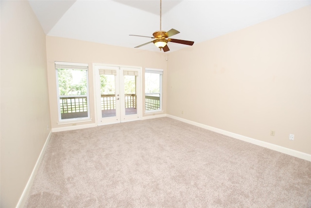 empty room with french doors, light colored carpet, ceiling fan, and vaulted ceiling