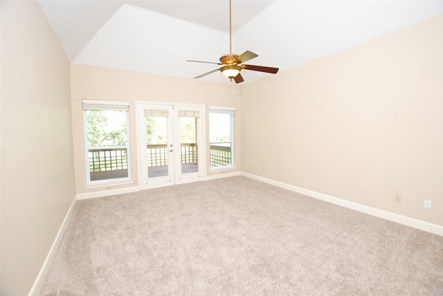 carpeted spare room with vaulted ceiling, ceiling fan, and french doors