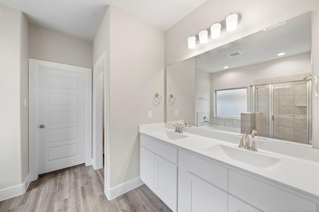 bathroom with hardwood / wood-style flooring, vanity, and shower with separate bathtub