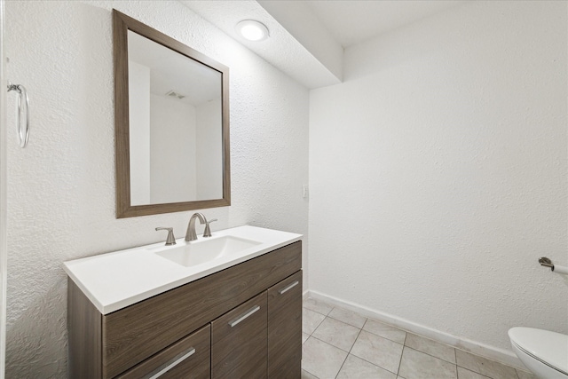 bathroom with tile patterned flooring, vanity, and toilet