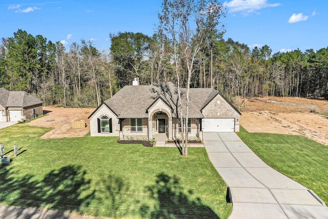 view of front of property with a front yard and a garage