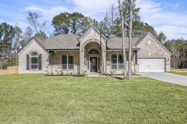 view of front of home with a garage and a front lawn