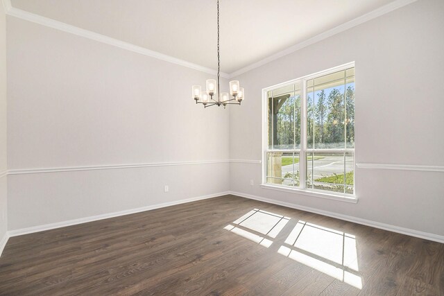 empty room featuring a chandelier, dark hardwood / wood-style flooring, and crown molding