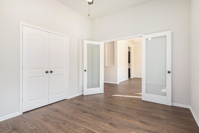 unfurnished bedroom featuring french doors, ceiling fan, dark hardwood / wood-style floors, a closet, and lofted ceiling