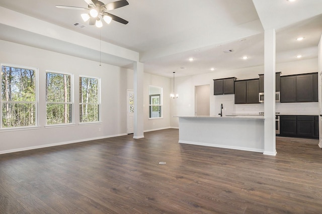 unfurnished living room featuring ceiling fan, dark hardwood / wood-style flooring, and sink