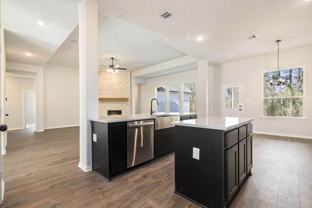 kitchen featuring dark hardwood / wood-style flooring, sink, dishwasher, a kitchen island, and hanging light fixtures