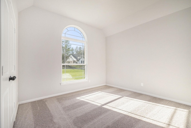 unfurnished room featuring light carpet and vaulted ceiling