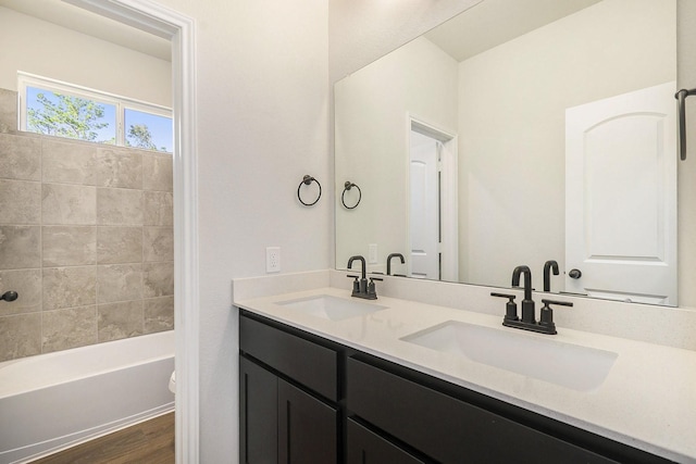 full bathroom with hardwood / wood-style floors, vanity, toilet, and tiled shower / bath