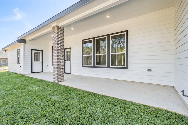 back of property featuring a patio area and a yard