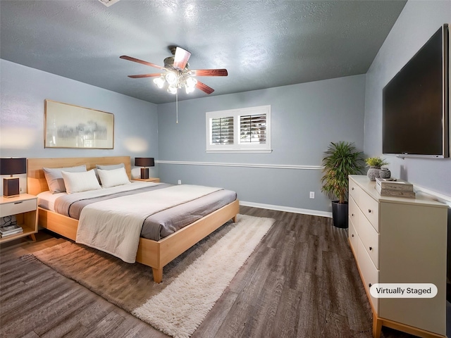 bedroom featuring ceiling fan, dark wood-type flooring, and a textured ceiling