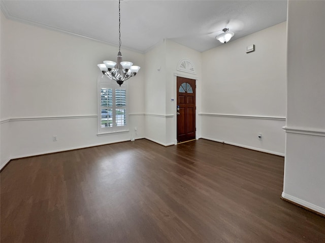 foyer featuring dark hardwood / wood-style flooring, an inviting chandelier, and crown molding