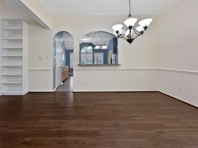 unfurnished dining area with built in shelves, crown molding, dark hardwood / wood-style flooring, and an inviting chandelier