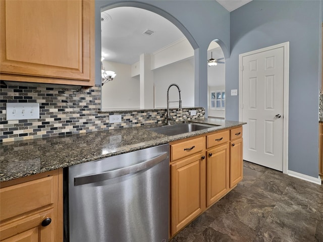 kitchen featuring dishwasher, sink, dark stone countertops, decorative backsplash, and ceiling fan with notable chandelier