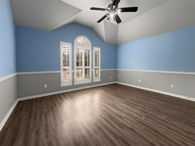 spare room with ceiling fan, dark wood-type flooring, and vaulted ceiling