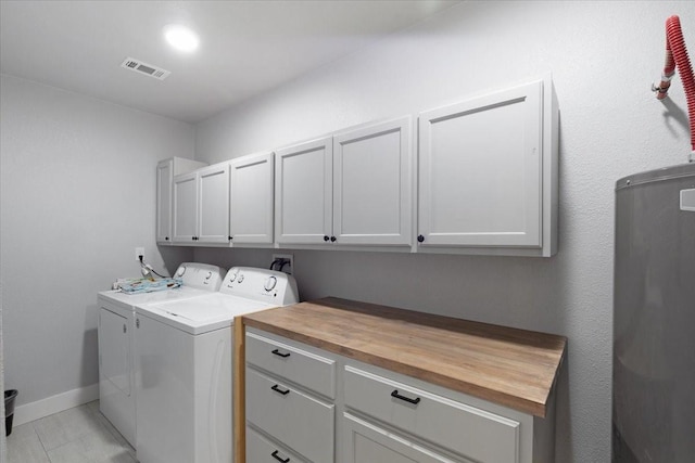 laundry room featuring cabinets, light tile patterned floors, and washing machine and dryer