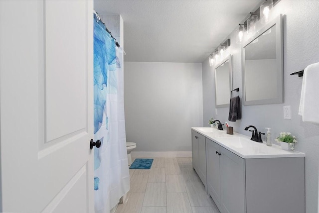 bathroom with vanity, toilet, and a textured ceiling