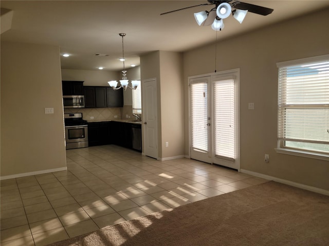 kitchen with pendant lighting, decorative backsplash, light tile patterned floors, appliances with stainless steel finishes, and plenty of natural light