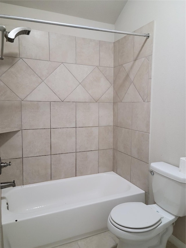 bathroom with toilet and tiled shower / bath