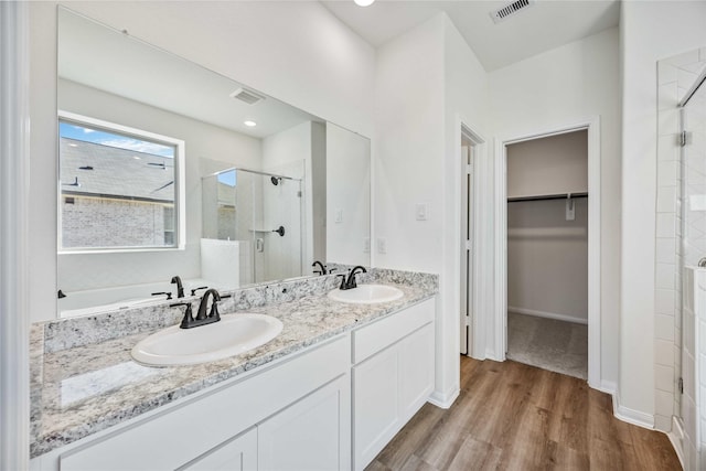 bathroom with vanity, hardwood / wood-style flooring, and a shower with shower door