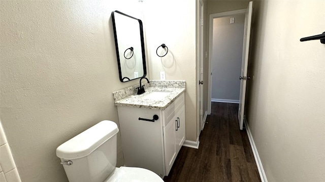 bathroom with toilet, vanity, and hardwood / wood-style flooring