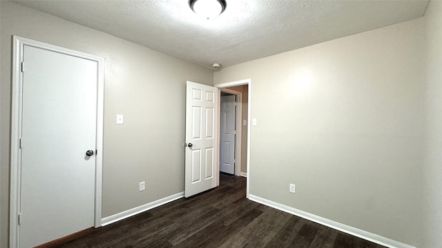 unfurnished bedroom with dark hardwood / wood-style floors and a textured ceiling