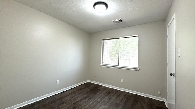 unfurnished room with a textured ceiling and dark hardwood / wood-style floors