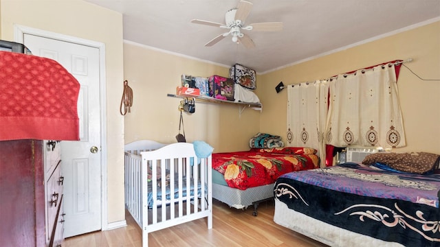 bedroom with light hardwood / wood-style floors, ceiling fan, and crown molding