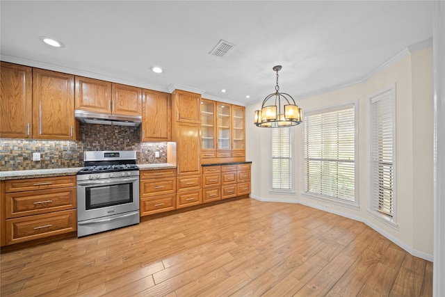 kitchen with light wood-type flooring, crown molding, pendant lighting, a notable chandelier, and stainless steel range with gas cooktop