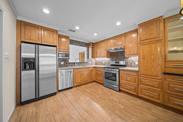 kitchen with sink, light hardwood / wood-style floors, decorative backsplash, appliances with stainless steel finishes, and ornamental molding