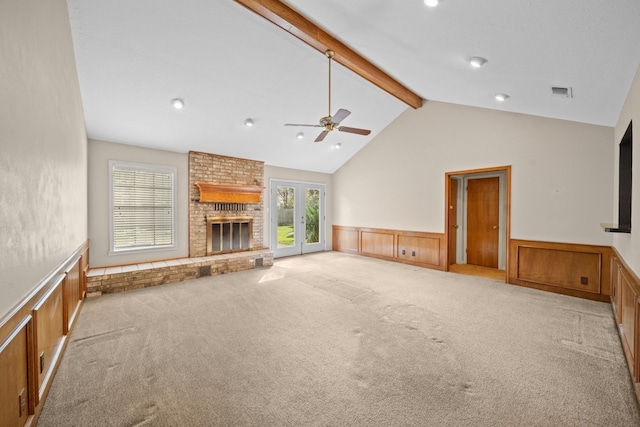 unfurnished living room featuring lofted ceiling with beams, light colored carpet, a brick fireplace, and ceiling fan