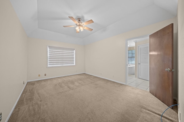 spare room featuring light colored carpet, ceiling fan, and a tray ceiling