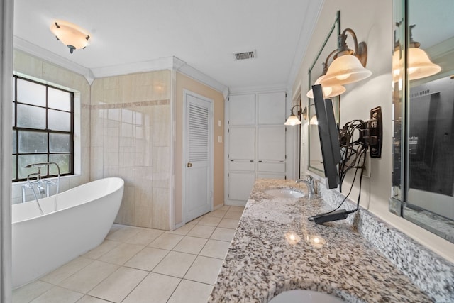 bathroom with tile patterned flooring, a bathtub, ornamental molding, and vanity