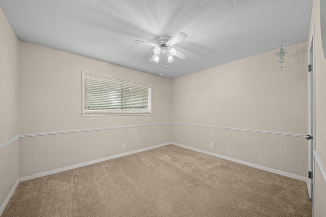 carpeted empty room featuring a textured ceiling and ceiling fan