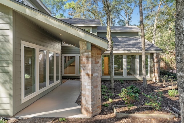 view of exterior entry with a patio