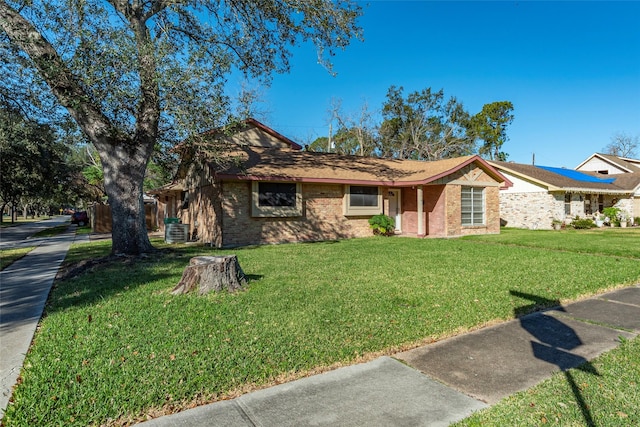 ranch-style house with a front yard and cooling unit