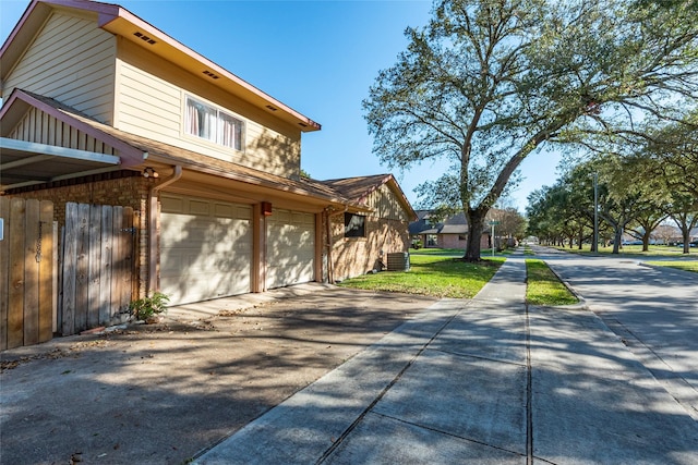 view of home's exterior with central AC and a garage