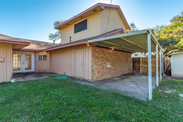 back of house featuring a lawn, french doors, and a patio