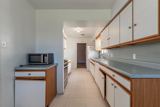 kitchen with white cabinetry, sink, light tile patterned floors, and appliances with stainless steel finishes