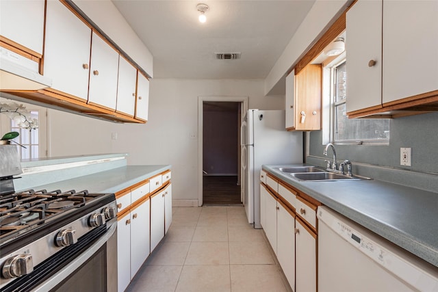 kitchen with white cabinetry, sink, and white appliances