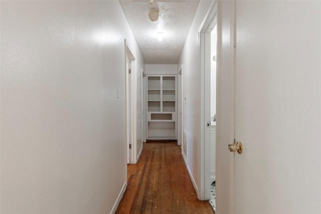 hallway featuring dark hardwood / wood-style flooring and a textured ceiling