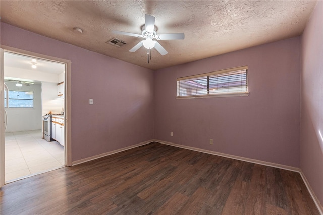 unfurnished room with wood-type flooring and a textured ceiling