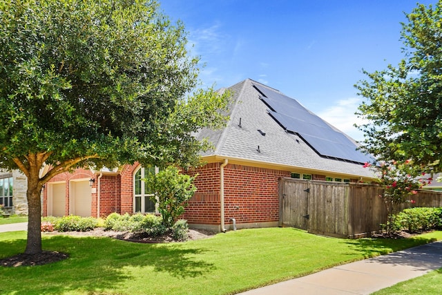 view of side of property with solar panels, a yard, and a garage