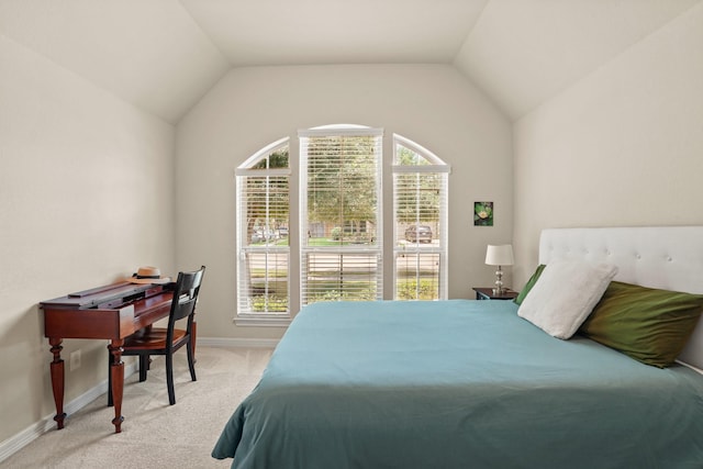 carpeted bedroom with lofted ceiling and multiple windows