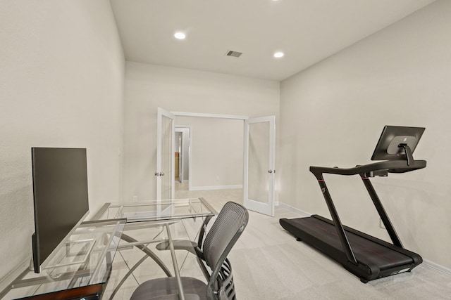 workout room featuring light carpet and french doors