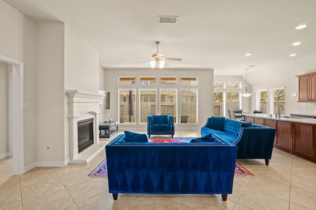 tiled living room featuring ceiling fan and sink