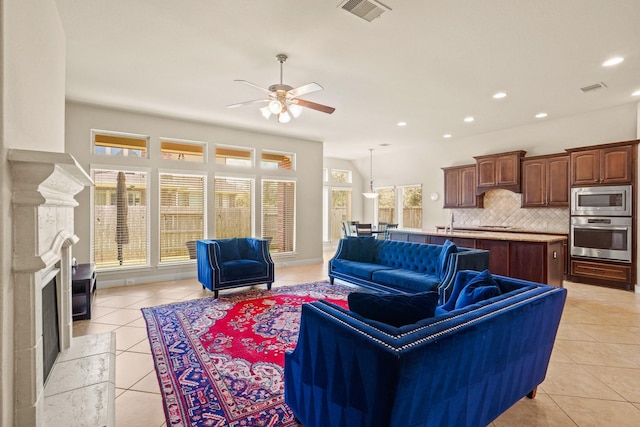 tiled living room featuring ceiling fan and a high end fireplace