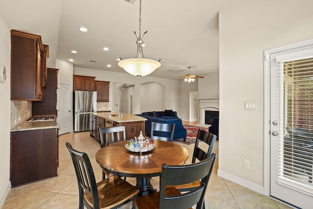 tiled dining space featuring ceiling fan and sink