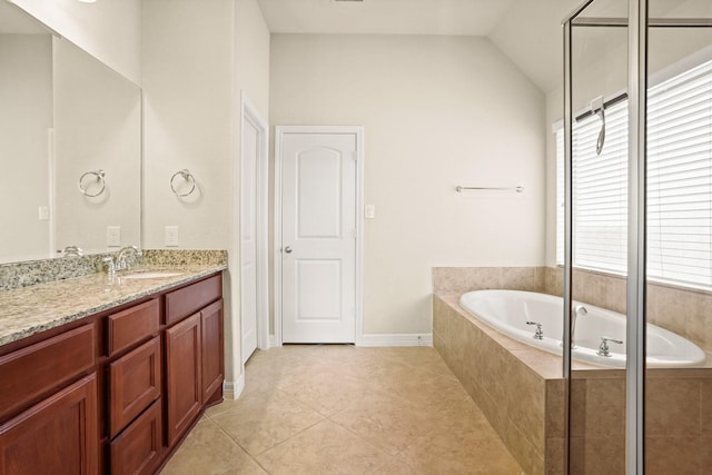 bathroom with vanity, tile patterned flooring, a relaxing tiled tub, and vaulted ceiling