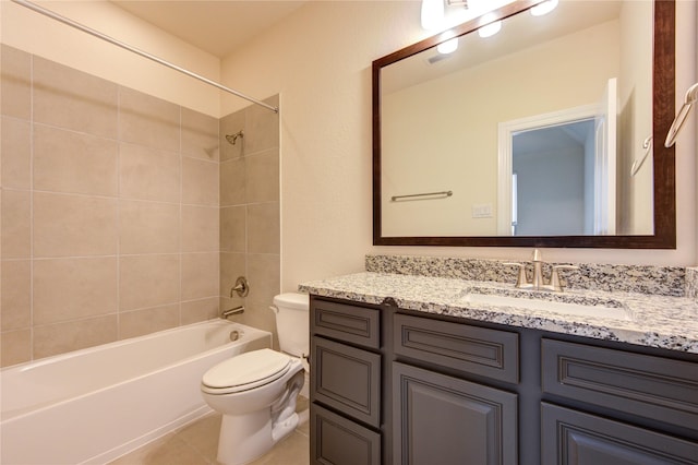 full bathroom featuring tile patterned floors, vanity, toilet, and tiled shower / bath