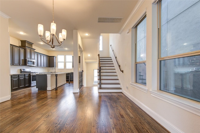 kitchen featuring a center island, stainless steel appliances, pendant lighting, a kitchen bar, and dark brown cabinets